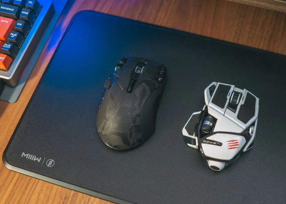 A large black desk mat covering a gaming desk