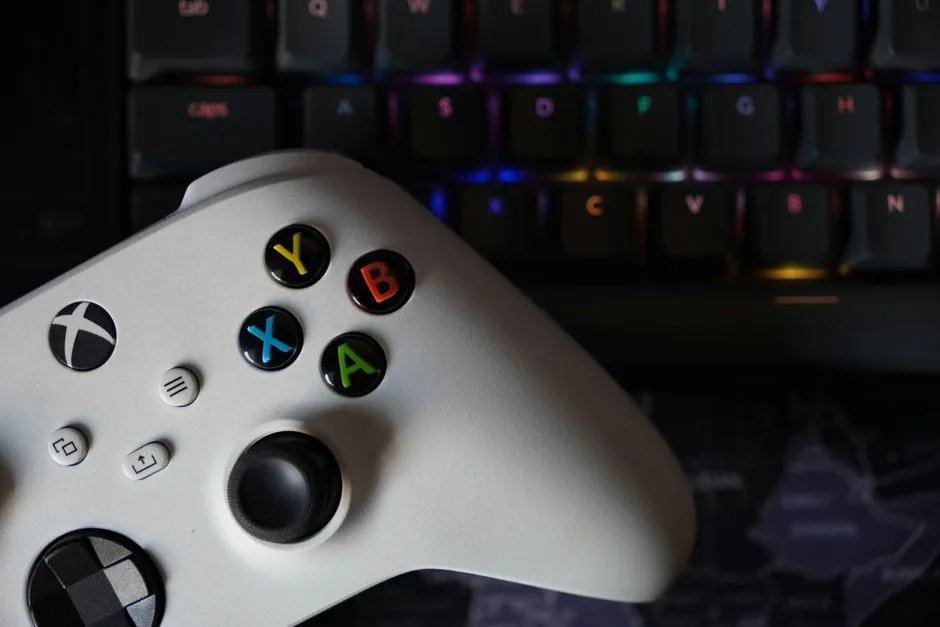 A white gaming pc build desk setup with an all-white keyboard and controller