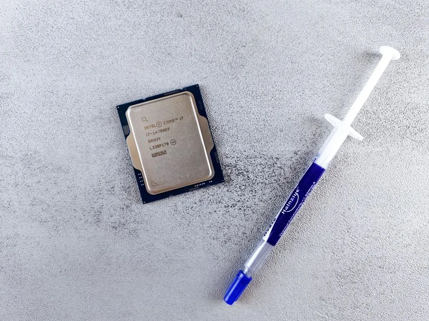 Tube of premium thermal paste beside a CPU and cooler