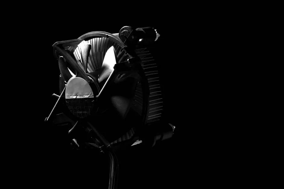 A technician cleaning dust from a CPU heatsink with compressed air
