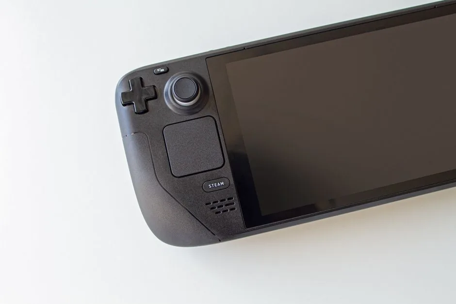 Two handheld gaming PCs charging beside their dock and cables