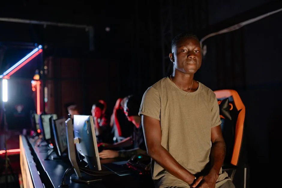 a young gamer competing in a dimly lit gaming arena with teammates